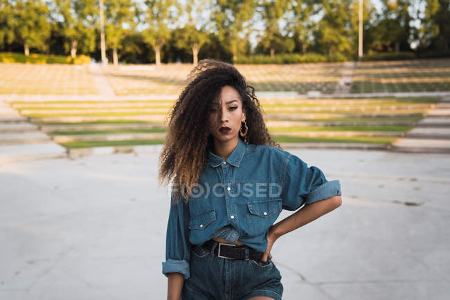 Молода жінка в джинсового одягу, стоячи в парку — стокове фото