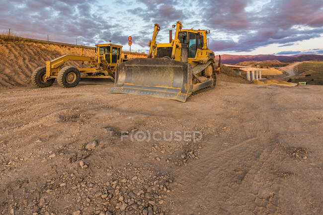 Bulldozer en la carretera de la carretera sin pavimentar - foto de stock