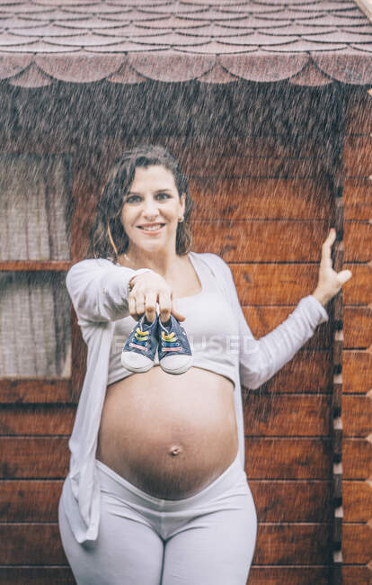 Hermosa mujer embarazada posando bajo la lluvia - foto de stock