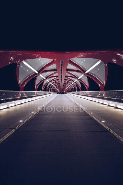 Perspektivischer Blick auf den modernen Bau einer Fußgängerbrücke, die in dunkler Nacht beleuchtet wird, Kanada — Stockfoto