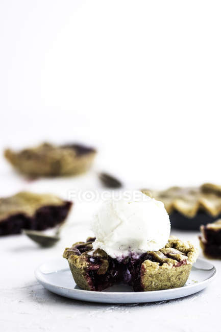 Tartlet with berry and ice cream on saucer on white background — Stock Photo