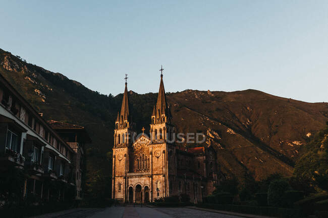 Amazing old church standing near picturesque mountains on cloudless day — Stock Photo