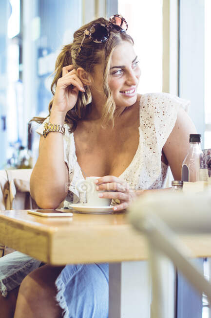 Приваблива жінка тримає білу чашку в руці — стокове фото