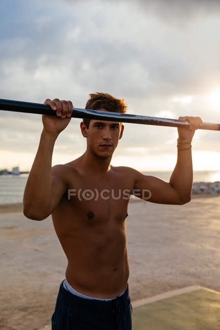 Young man training on bars on the outside — Stock Photo