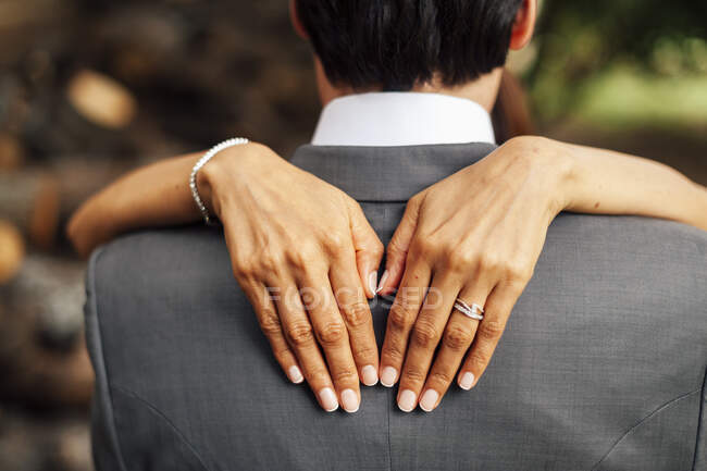 Hand des unkenntlichen Bräutigams umarmt Braut im weißen Kleid. — Stockfoto