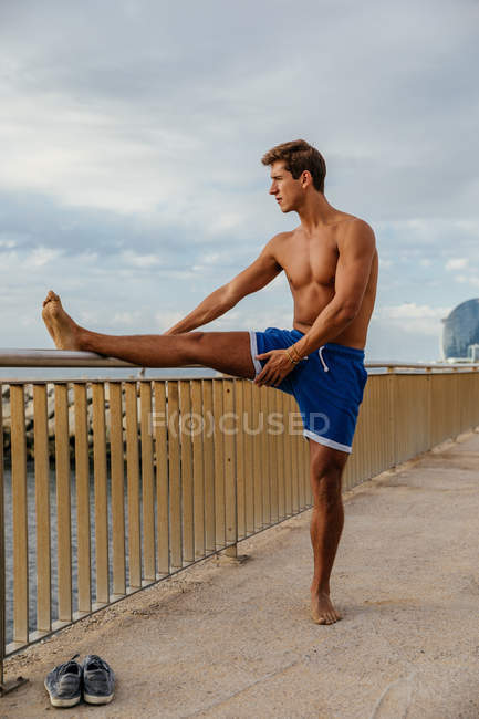 Hombre atleta haciendo estiramiento fuera - foto de stock
