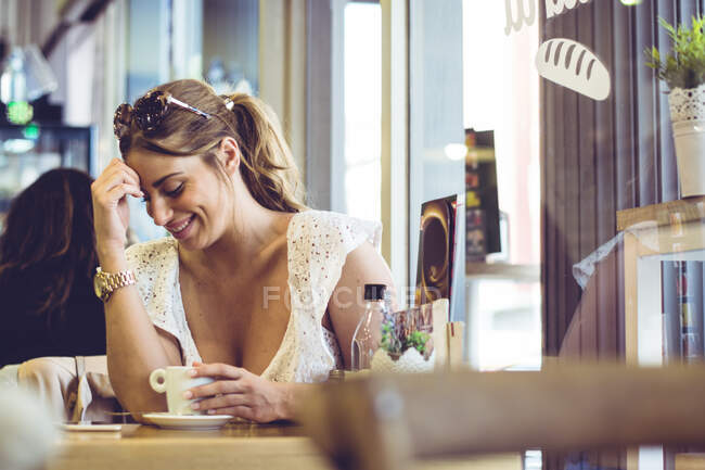 Attractive female holding white cup in hand — Stock Photo