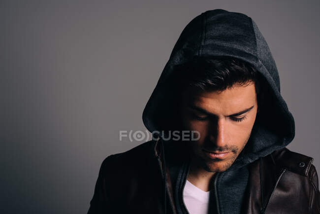 Jeune homme brunet attrayant portant un sweat à capuche dans un studio — Photo de stock