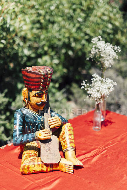 Vintage pfeifenden Mann Figur und Flaschen mit rustikalen weißen Blumen. — Stockfoto