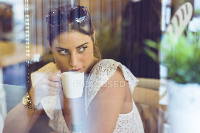 Attractive female holding white cup in hand — Stock Photo