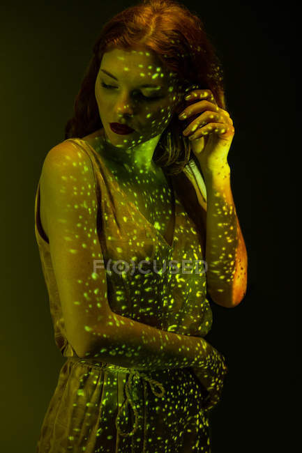 Чуттєва елегантна жінка позує в теплому світлі в темній кімнаті — стокове фото