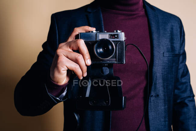Junger Mann in einem Studio mit einer Vintage-Kamera — Stockfoto