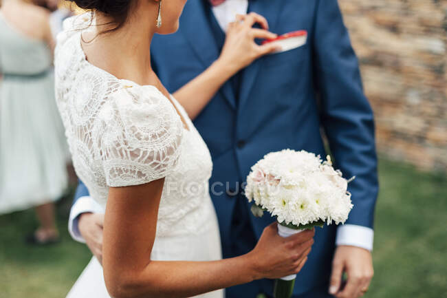 Cortar feliz casal recém-casado beijando no evento de casamento. — Fotografia de Stock
