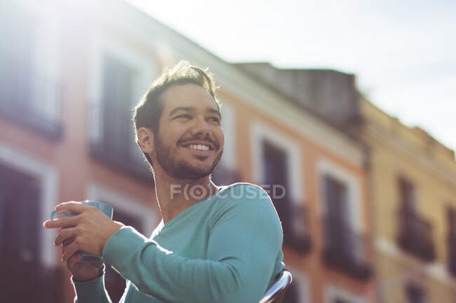 Young man drinking coffee outdoors — Stock Photo