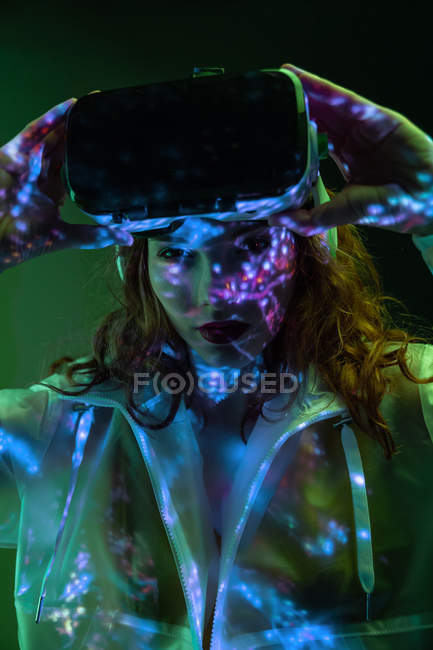 Jovem mulher usando óculos VR em luz de néon — Fotografia de Stock