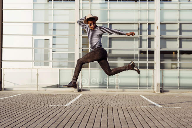 Stylish black man jumping on street — Stock Photo