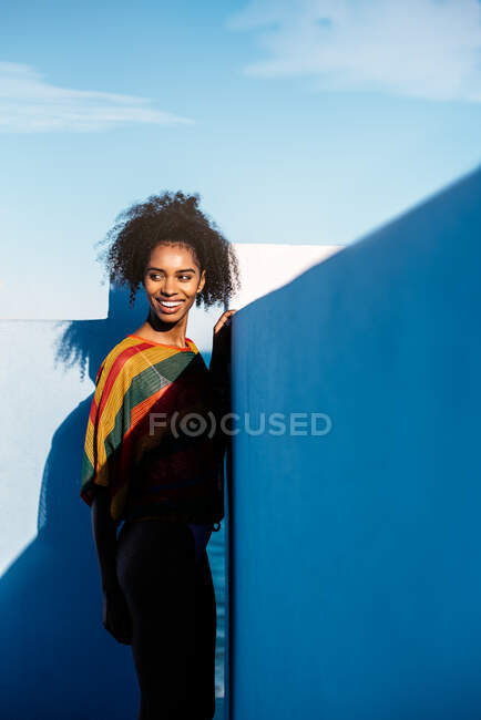 Schwarze Frau lehnt in blauer Wand in Sommerkleidung — Stockfoto