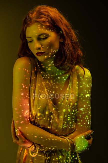 Sensual mulher elegante em pé em manchas de luz quente — Fotografia de Stock