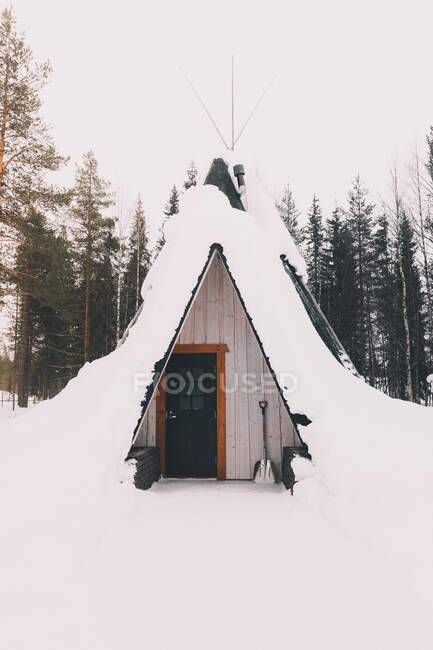 Зовнішній вигляд маленької житлової вігвамської кабіни, покритої снігом у віддалених спокійних лісах — стокове фото