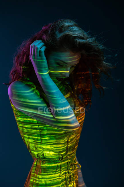 Мрійлива жінка позує в плямах теплого світла — стокове фото
