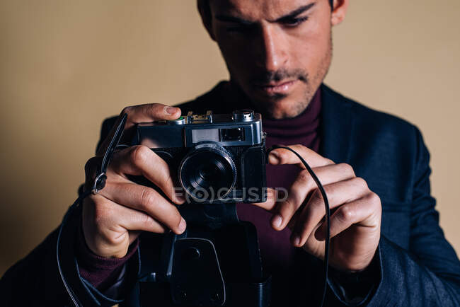 Молодий чоловік у студії з вінтажною камерою. — стокове фото