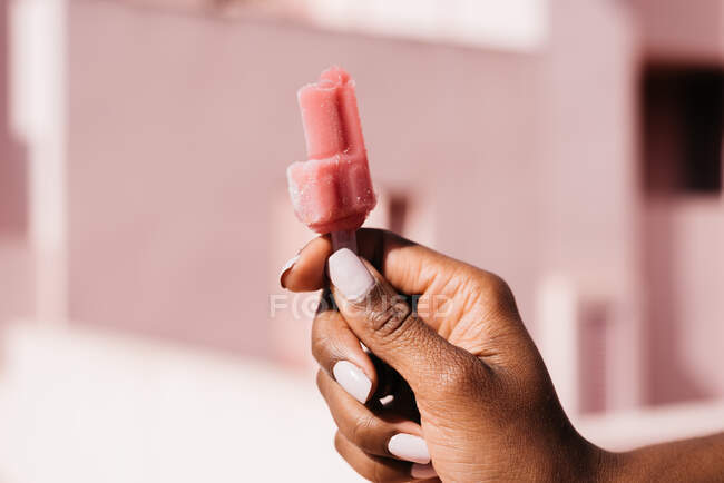 Mani nere donna con un ghiacciolo colorato — Foto stock