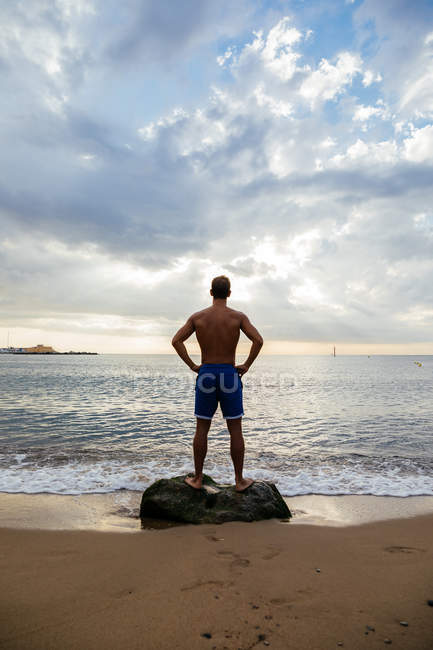 Giovane atleta posa in riva al mare — Foto stock