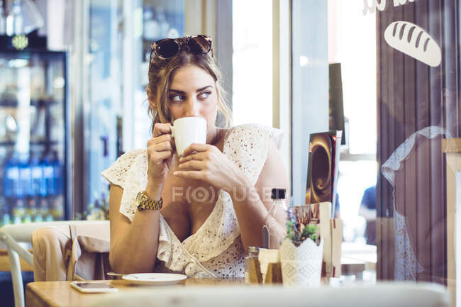 Приваблива жінка тримає білу чашку в руці — стокове фото