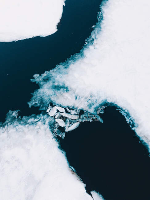Сверху беспилотник видит темно-голубую воду с кусками движущегося льда — стоковое фото