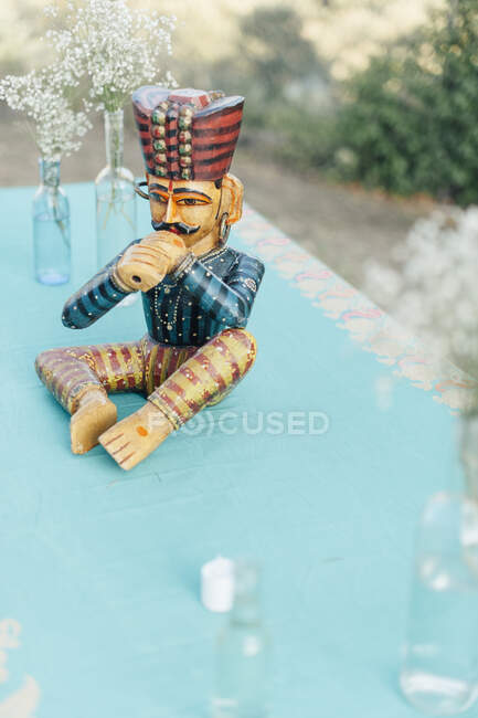 Vintage whistling man figurine and bottles with rustic white flowers. — Stock Photo