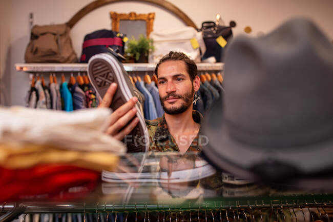 Веселий чоловік вибирає одяг та аксесуари в магазині — стокове фото