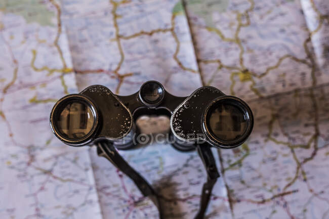 Planeando un viaje en un mapa con prismáticos antiguos - foto de stock