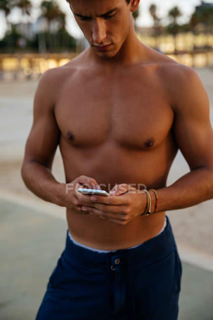 Atleta homem treinando ao ar livre com móvel — Fotografia de Stock