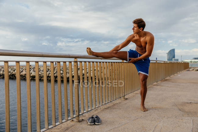 Hombre atleta haciendo estiramiento fuera - foto de stock