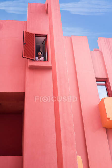 Черная женщина стоит в красочных геометрических окнах здания — стоковое фото