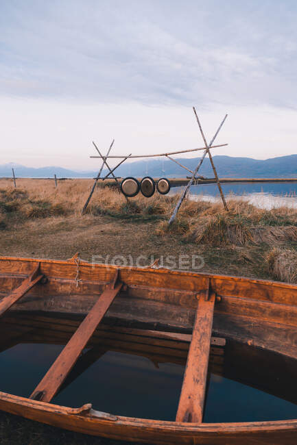 Vista do barco velho de madeira enchido com água na costa fria com construção de madeira e discos de metal — Fotografia de Stock