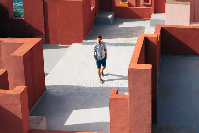 Man walking in a colorful geometric building roof terrace — Stock Photo