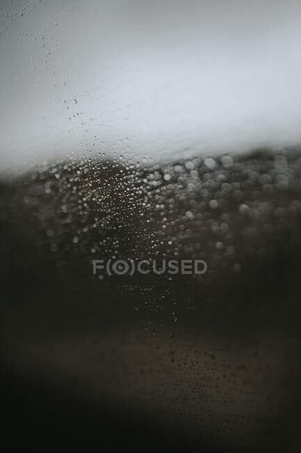 Nahaufnahme einer Glasoberfläche, die mit winzigen Regentropfen bedeckt ist — Stockfoto