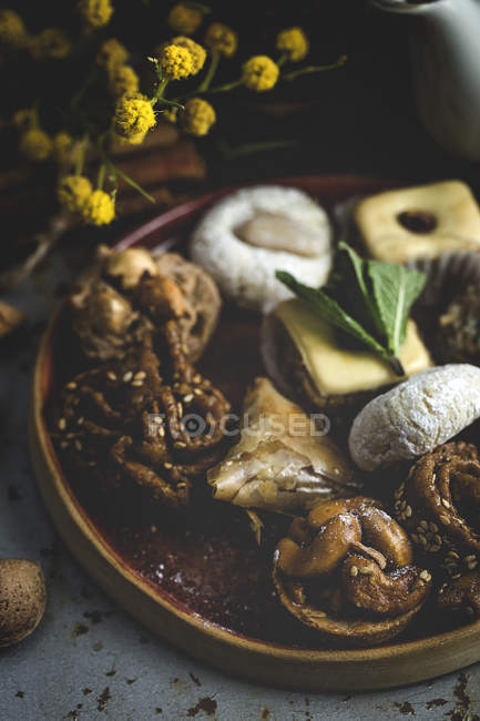 Типичные домашние марокканские сладости с медом и миндалем на деревянном блюде — стоковое фото