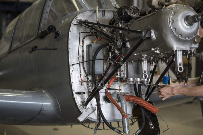 Руки авіаційного механічного кріплення двигуна малого літака в ангарі — стокове фото