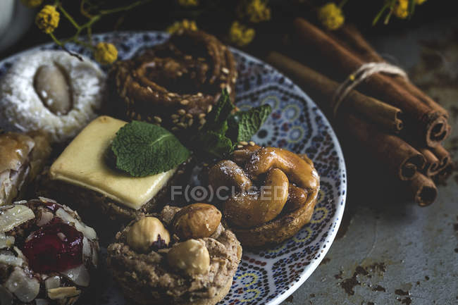 Dulces marroquíes caseros típicos con miel y almendras en plato estampado - foto de stock