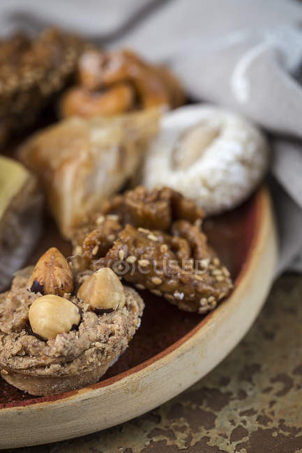 Крупный план типичных марокканских сладостей с медом и миндалем на тарелке — стоковое фото