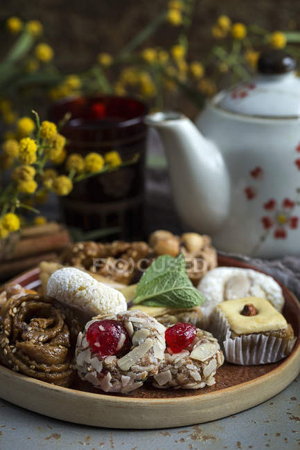 Типичные марокканские сладости с медом и миндалем на деревянной тарелке — стоковое фото