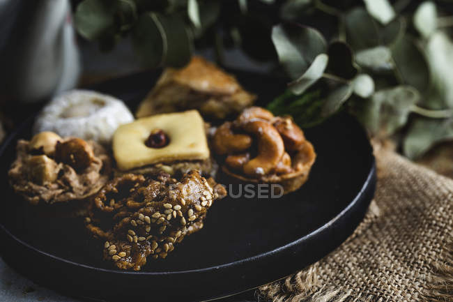 Typisch marokkanische Süßigkeiten mit Honig und Mandeln auf schwarzem Teller — Stockfoto