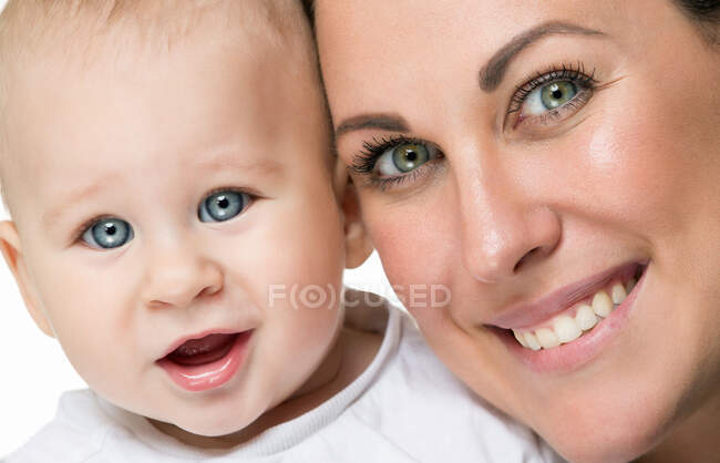 Fröhliche Mutter und glücklicher Kleinkind schauen gemeinsam in die Kamera. — Stockfoto