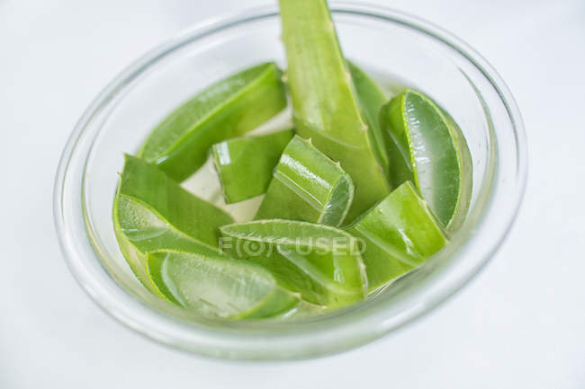 Pieces of fresh green Aloe Vera with white flesh in glass bowl — Stock Photo