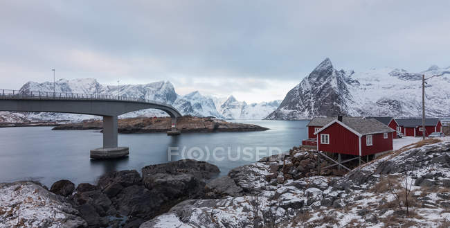 Red wooden huts on remote shore in mountains — Stock Photo