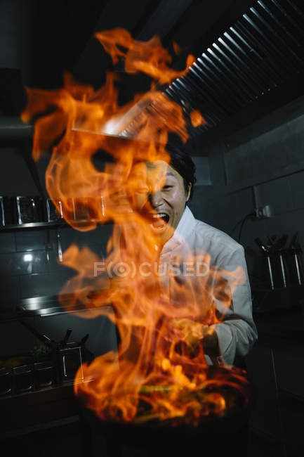 Схвильований кухар, що робить флампа на кухні ресторану — стокове фото