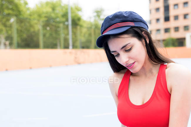 Портрет посміхаючись молода жінка, сидячи на спортивний майданчик — стокове фото