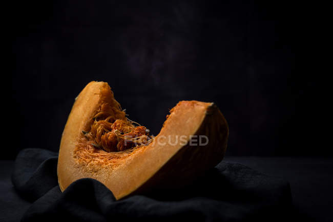 Piece of fresh pumpkin on black fabric — Stock Photo